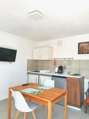 a kitchen with a wooden table and white chairs at Loft for 2 in Rhodes town near Elli beach in Rhodes Town