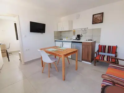 a kitchen with a wooden table and a table and chairs at Loft for 2 in Rhodes town near Elli beach in Rhodes Town