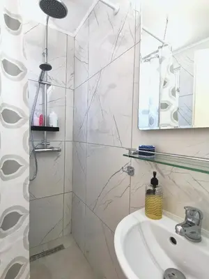 a white bathroom with a shower and a sink at Loft for 2 in Rhodes town near Elli beach in Rhodes Town