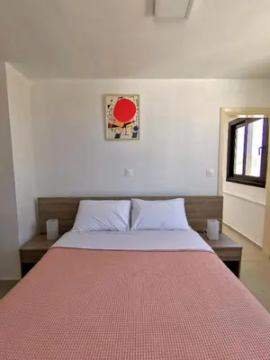 a bedroom with a large bed with a red blanket at Loft for 2 in Rhodes town near Elli beach in Rhodes Town