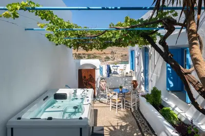a balcony with a hot tub and a tree at Lindos Beach Boutique Villa in Líndos