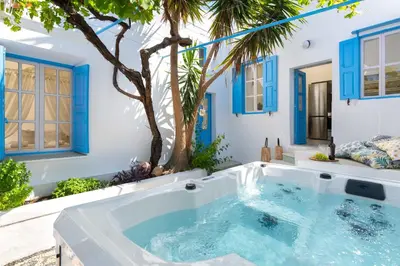 a jacuzzi tub in a backyard with a palm tree at Lindos Beach Boutique Villa in Líndos