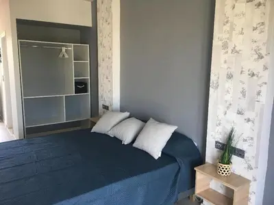 a bedroom with a blue bed with two pillows at RHODIAN TREASJURE Spiridione Studios in Faliraki
