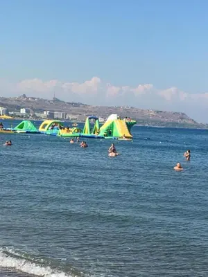 a group of people in the water at the beach at RHODIAN TREASJURE Spiridione Studios in Faliraki