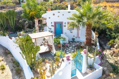 a house with a palm tree and a blue door at Archontiko Stegna in Archangelos