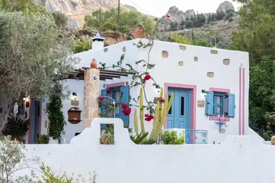 a house with white walls and blue doors at Archontiko Stegna in Archangelos
