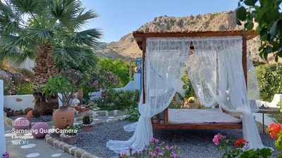 a bed in a garden with flowers and plants at Archontiko Stegna in Archangelos