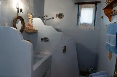 a white bathroom with a sink and a sink at Archontiko Stegna in Archangelos