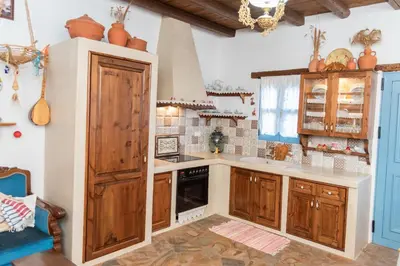 a kitchen with wooden cabinets and a stove top oven at Archontiko Stegna in Archangelos