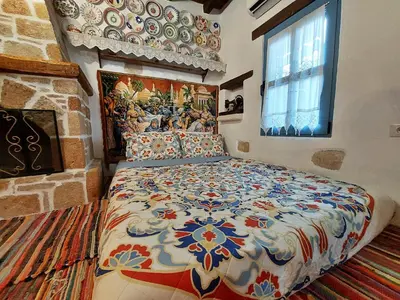 a bedroom with a bed with a painting on the wall at Archontiko Stegna in Archangelos