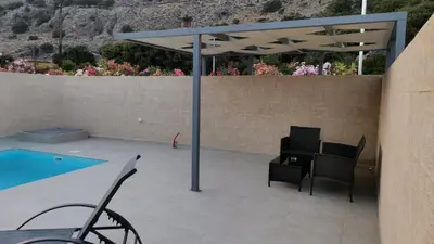 a patio with a table and chairs next to a pool at Tesoro Del Mare in Pefki Rhodes