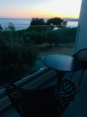 a table and chairs on a balcony with a view of the ocean at Tesoro Del Mare in Pefki Rhodes