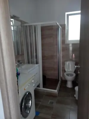 a bathroom with a toilet and a sink and a washing machine at TASSOS-Haus in Archangelos