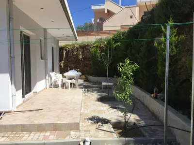 a patio with a table and chairs in a house at TASSOS-Haus in Archangelos