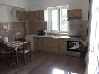 a kitchen with a table and a stove and a window at TASSOS-Haus in Archangelos