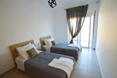 a hotel room with two beds and a window at S-EVA RESORT in Kolimbia
