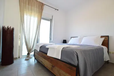 a bedroom with a large bed with a large window at S-EVA RESORT in Kolimbia
