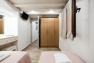 a room with two beds and a wooden door at Old Town Diamond in Rhodes Town