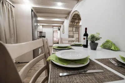 a dining room table with plates and a bottle of wine at Old Town Diamond in Rhodes Town