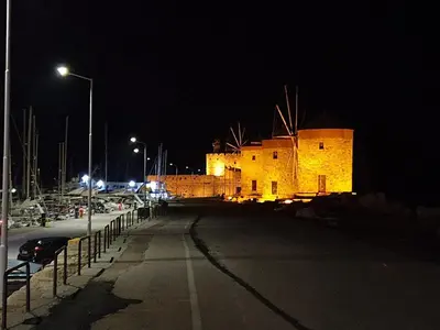 a lit up building at night with a street at Old Town Diamond in Rhodes Town