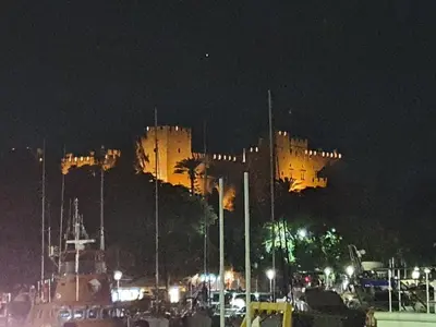 a large castle is lit up at night at Old Town Diamond in Rhodes Town