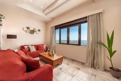 a living room with a red couch and a large window at Blue Vision Luxury House in Pefki Rhodes