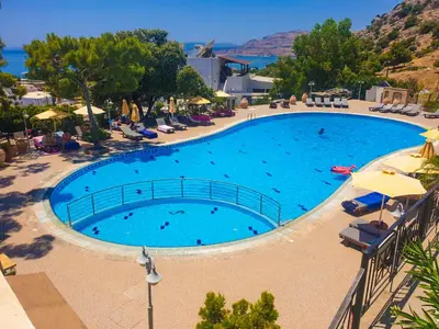 a large blue swimming pool with chairs and umbrellas at Blue Vision Luxury House in Pefki Rhodes
