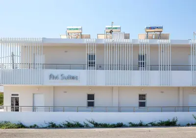 a white building with the am suites sign on it at Avi Suites Faliraki in Faliraki