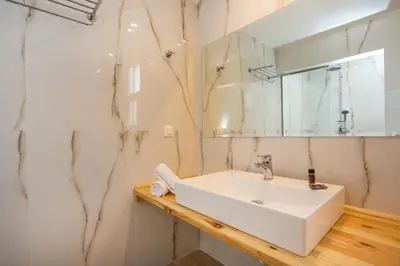 a bathroom with a white sink and a mirror at Avi Suites Faliraki in Faliraki
