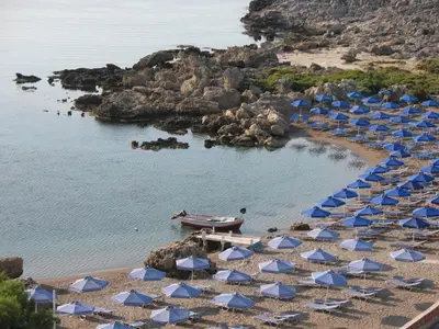 a group of beach chairs and umbrellas on a beach at Avi Suites Faliraki in Faliraki