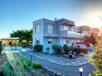 a large white building with a swimming pool in front of it at Villa Papagiorgio Luxury and Harmony in Gennadi
