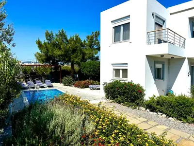 a house with a swimming pool next to a building at Villa Papagiorgio Luxury and Harmony in Gennadi