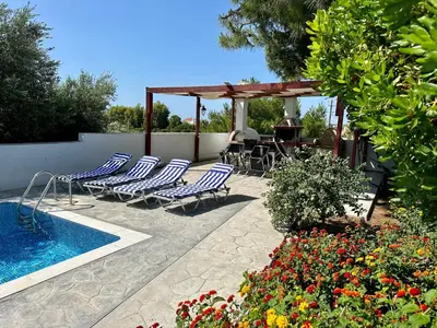 a patio with lounge chairs and a swimming pool at Villa Papagiorgio Luxury and Harmony in Gennadi