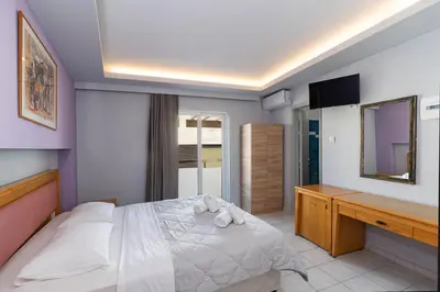 a bedroom with a bed with a desk and a television at N E P center Hotel Rodos in Rhodes Town