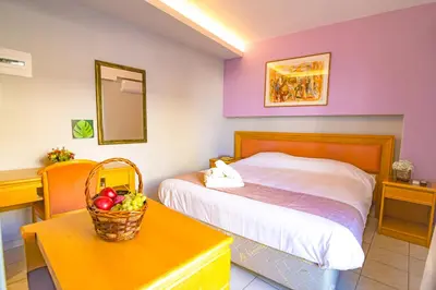 a bedroom with a bed and a table with a basket of fruit at N E P center Hotel Rodos in Rhodes Town
