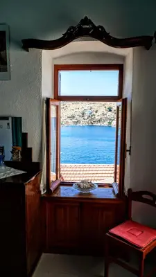 a window in a room with a view of the water at Villa Pitini in Symi