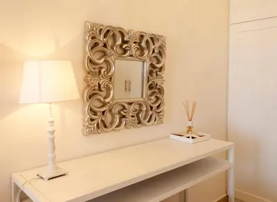 a mirror on a wall next to a table with a lamp at Luxury Villa Eos in vlicha