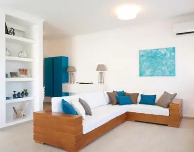 a living room with a white couch and blue pillows at Luxury Villa Eos in vlicha