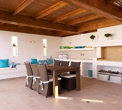 a dining room with a wooden table and chairs at Luxury Villa Eos in vlicha