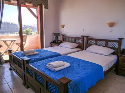 two beds in a bedroom with a view of a balcony at Luxury Villa Delfini in Líndos