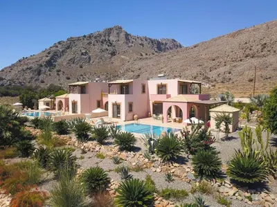 a house in the desert with a mountain in the background at Luxury Villa Delfini in Líndos