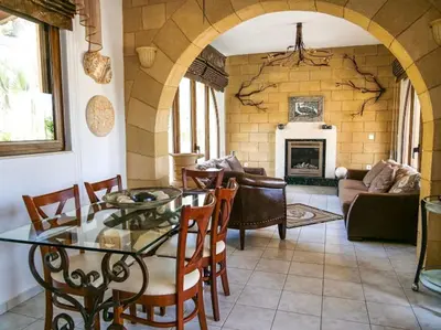 a living room with a table and chairs and a fireplace at Luxury Villa Delfini in Líndos