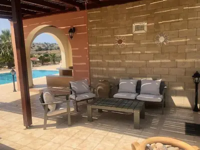 a patio with a couch and chairs and a table at Luxury Villa Delfini in Líndos