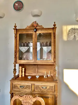 a wooden hutch with glass doors on a wall at Aetheria traditional house in Koskinou