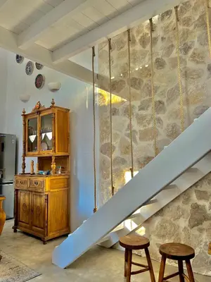 a staircase in a room with a stone wall at Aetheria traditional house in Koskinou