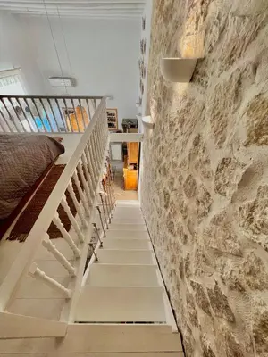 a staircase in a house with a stone wall at Aetheria traditional house in Koskinou