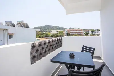 a table and chairs on a balcony with a view at Vickys Faliraki in Faliraki
