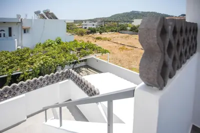 a view from the balcony of a house with a sculpture at Vickys Faliraki in Faliraki