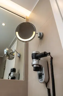 a mirror and a phone on a wall in a bathroom at Lindian Ethos in Líndos