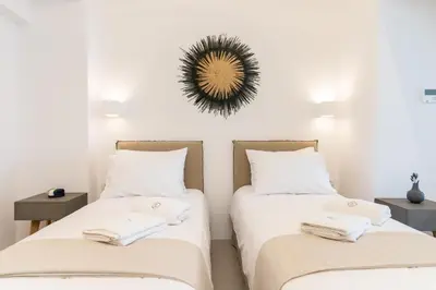 two beds in a room with a mirror on the wall at Lindian Ethos in Líndos